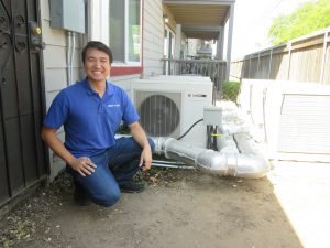 Daniel Chen in front of a heat pump water heater